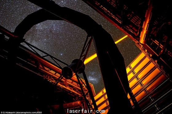 智利歐洲南方天文臺帕拉納爾天文臺操作的這個新PARLA激光器。從圖上可以看到，7瓦特激光器發出的橙黃色光束從甚大望遠鏡的望遠鏡4的穹隆結構射向高空。在背景圖上還能看到大麥哲倫云